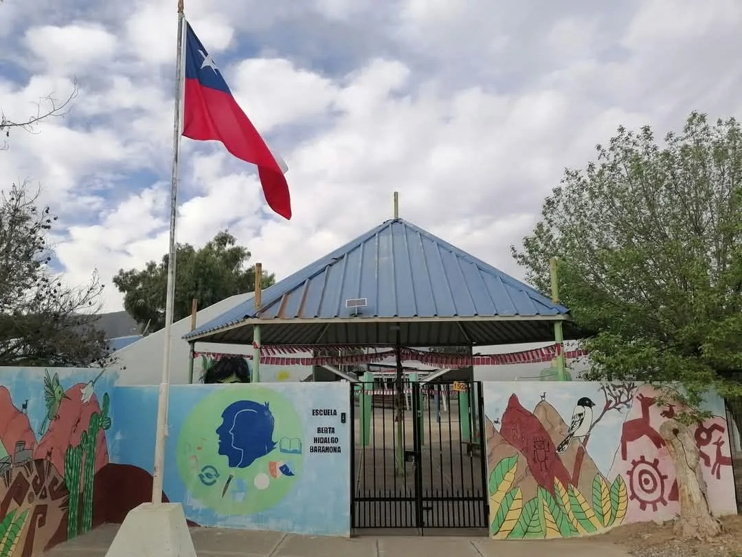 Entrada de la Escuela Berta Hidalgo Barahona con sus murales y bandera chilena